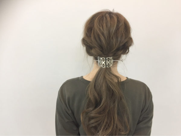 両サイドをゆるく編み込みして後ろでまとめたヘアアレンジ。抜け感がかわいい大人のホリデーアレンジにマジェステをONするとオシャレ感UP！